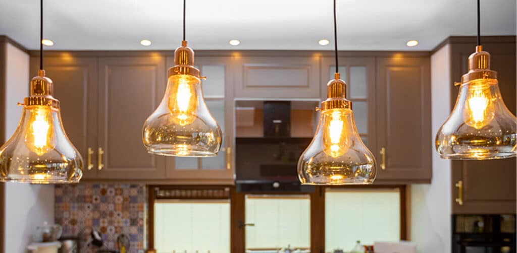 A bright kitchen featuring numerous lights elegantly suspended from the ceiling, creating a warm and inviting atmosphere.
